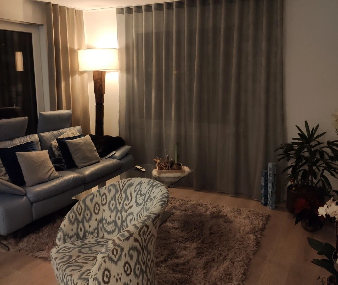 Gemütliches kleines Wohnzimmer mit blau weiss gemusterterten selber bezogen Drehsessel von 3inDesign aus Schaffhausen